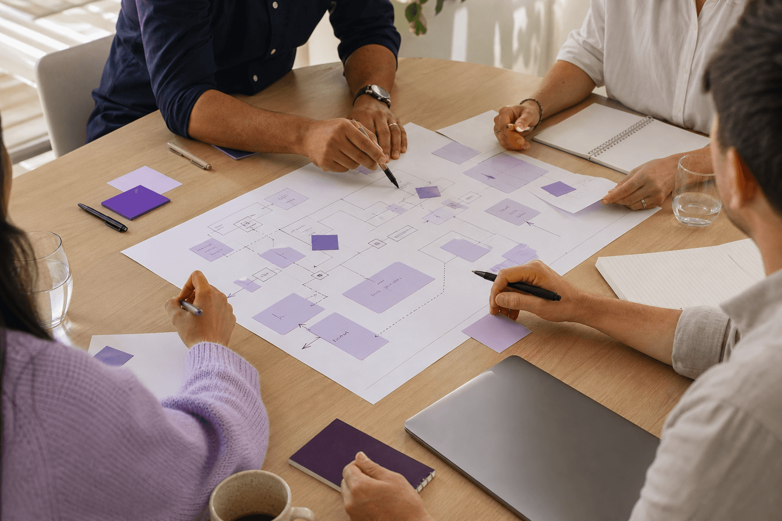 Colleagues mapping a connected workflow together around a table